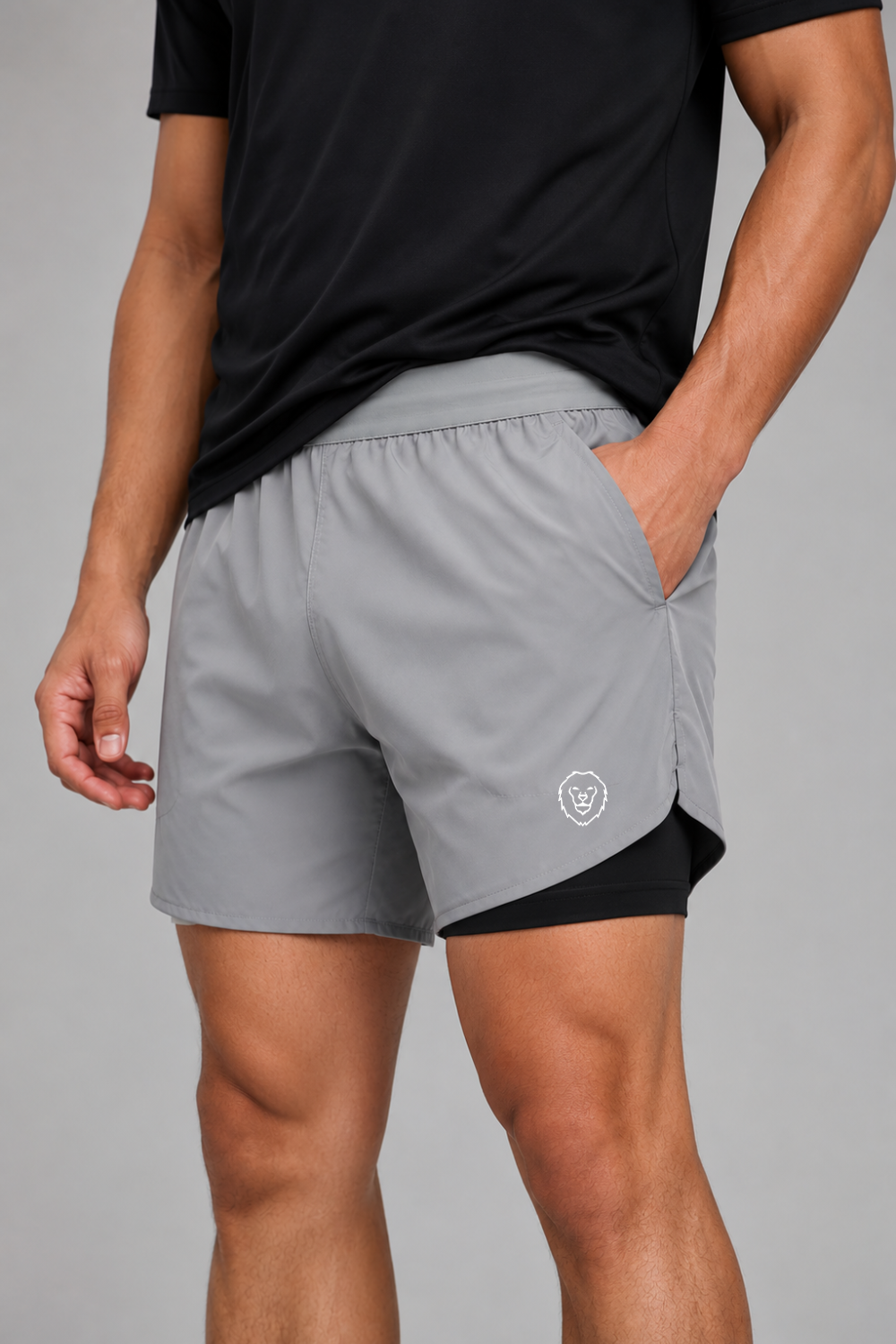 Person wearing gray athletic shorts with a black logo on a gray background