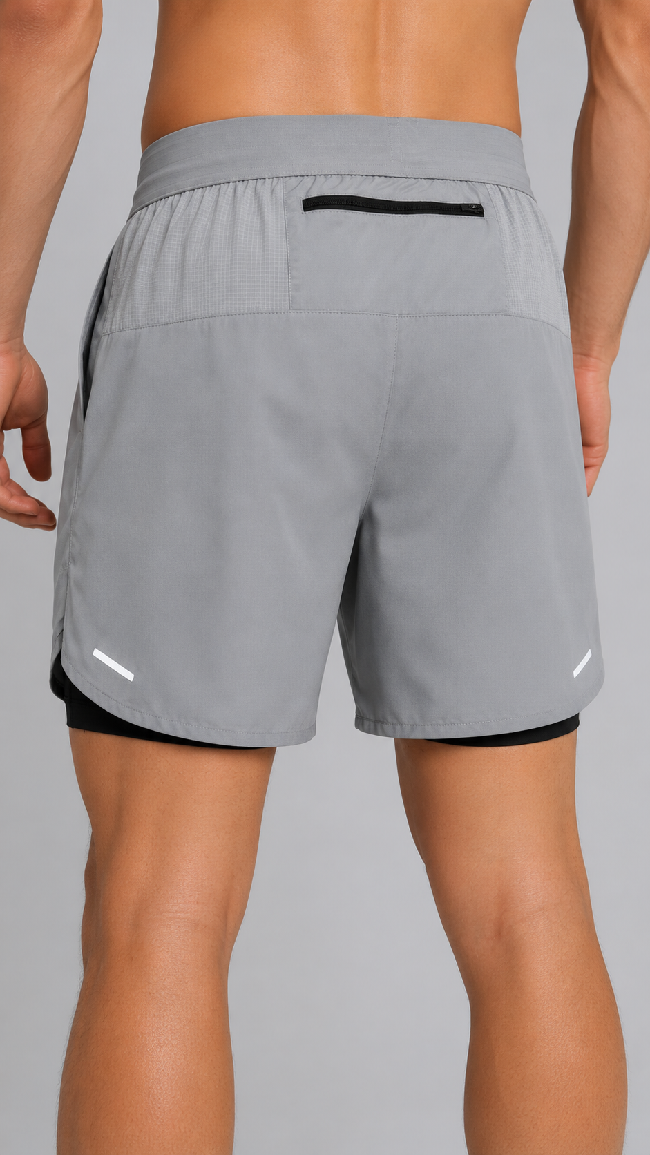 Gray athletic shorts with a black waistband and pocket on a gray background