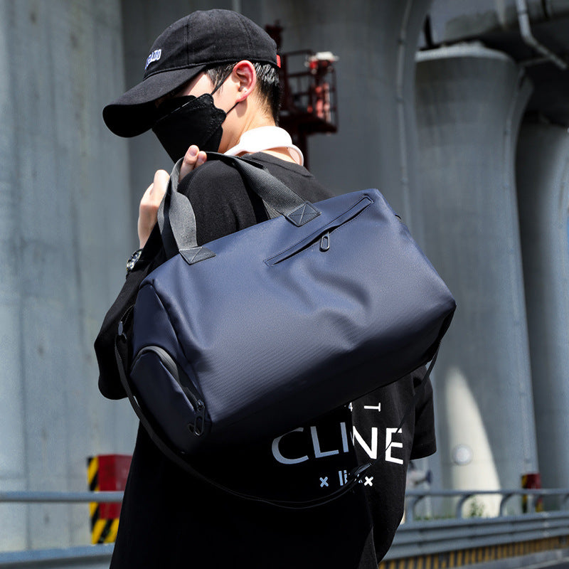 Person carrying a navy blue duffel bag with a blurred background