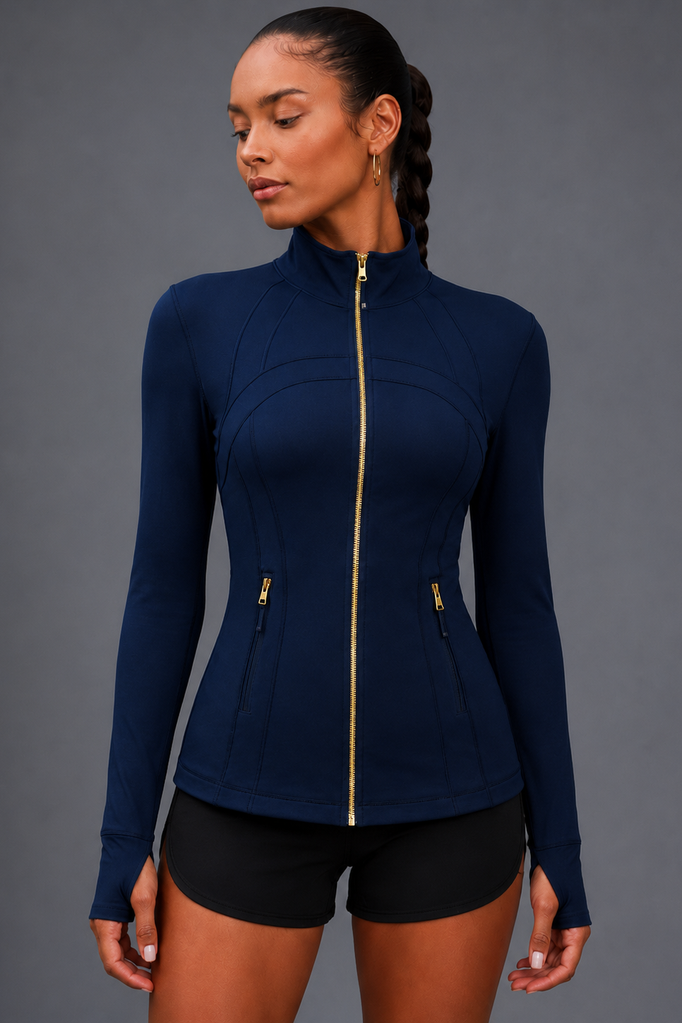 Woman wearing a navy blue athletic jacket with a gold zipper on a gray background