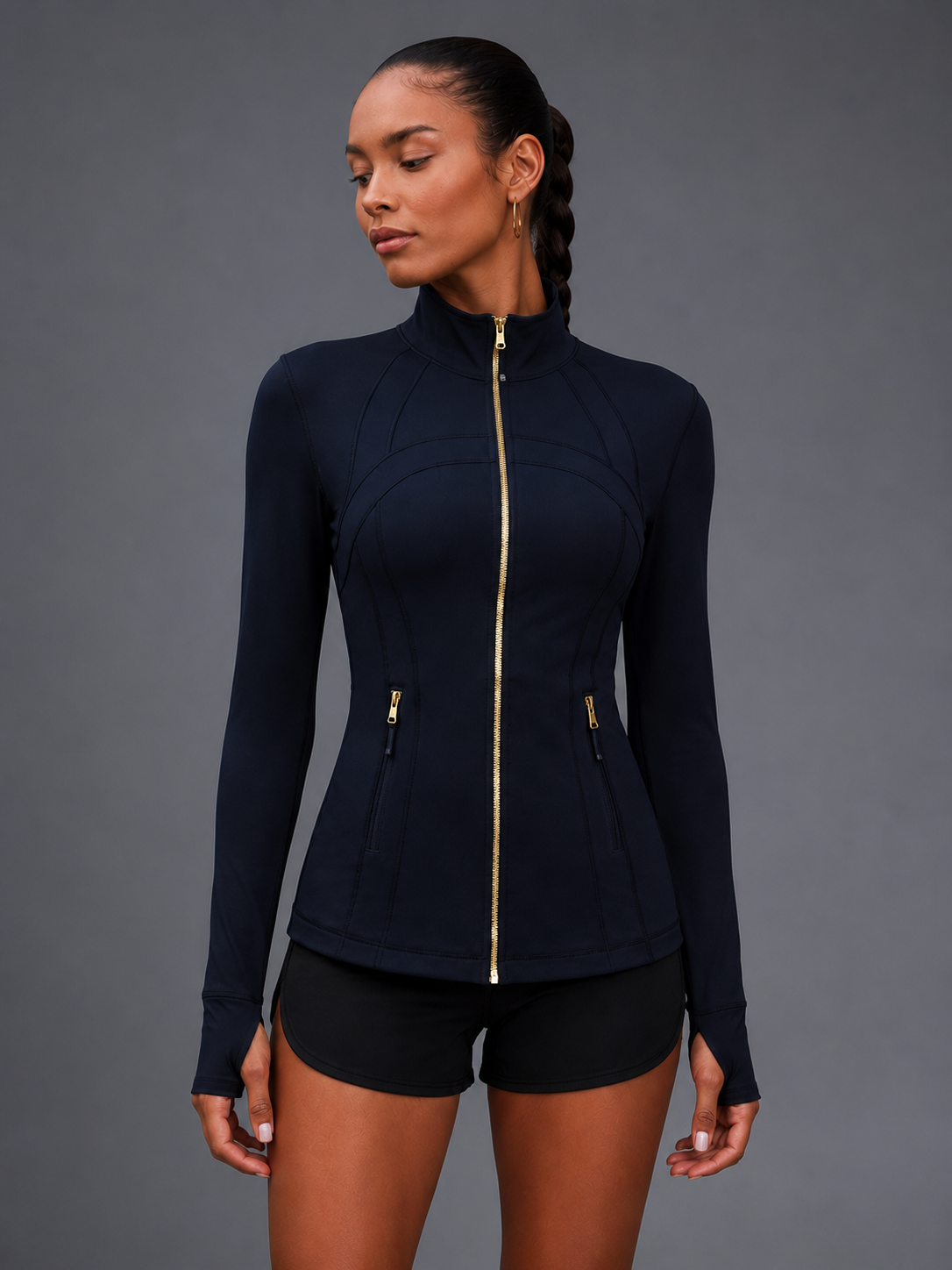 Woman wearing a black long-sleeve athletic top with a zipper on a gray background