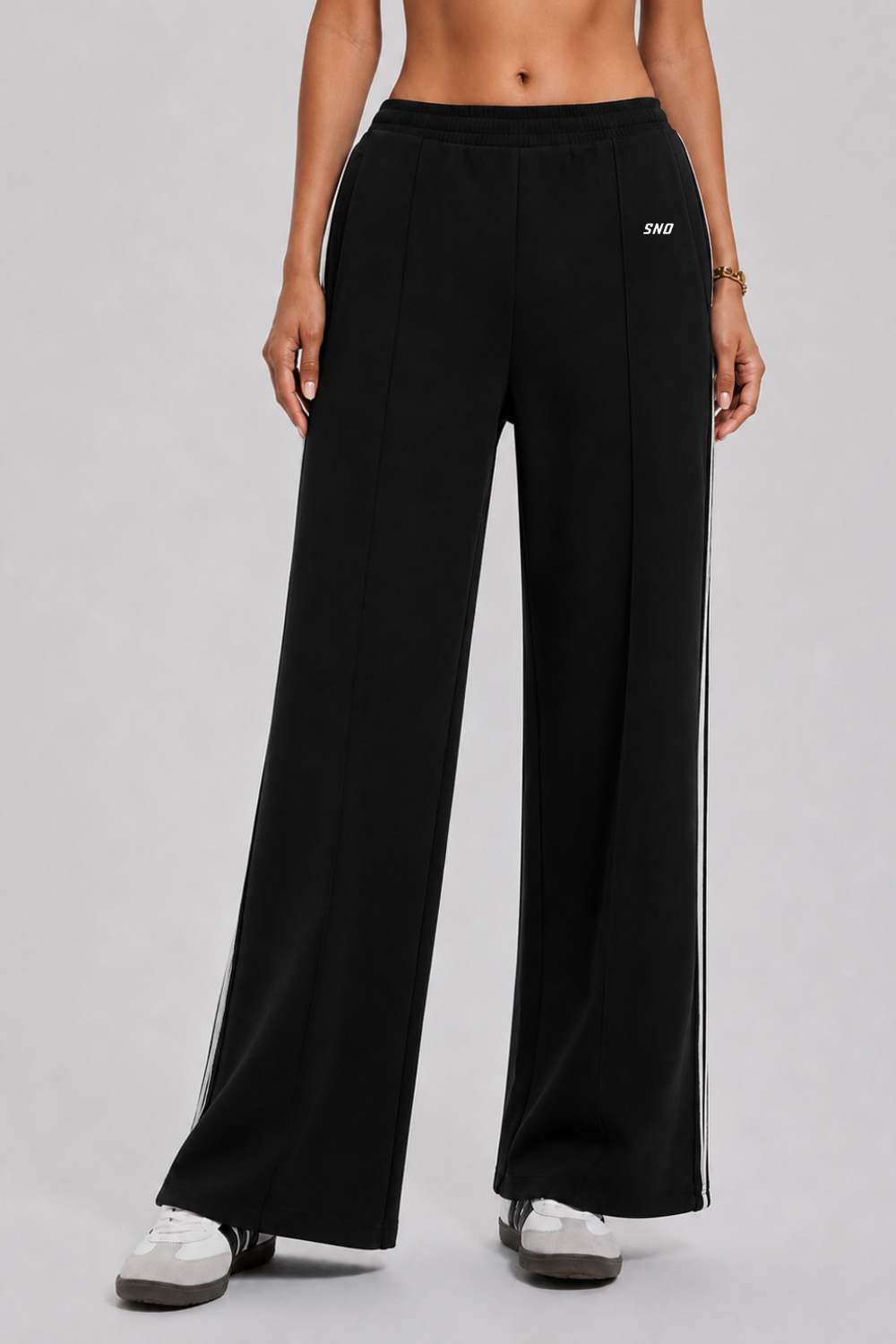 Person wearing black wide-leg pants with a brand logo on a gray background