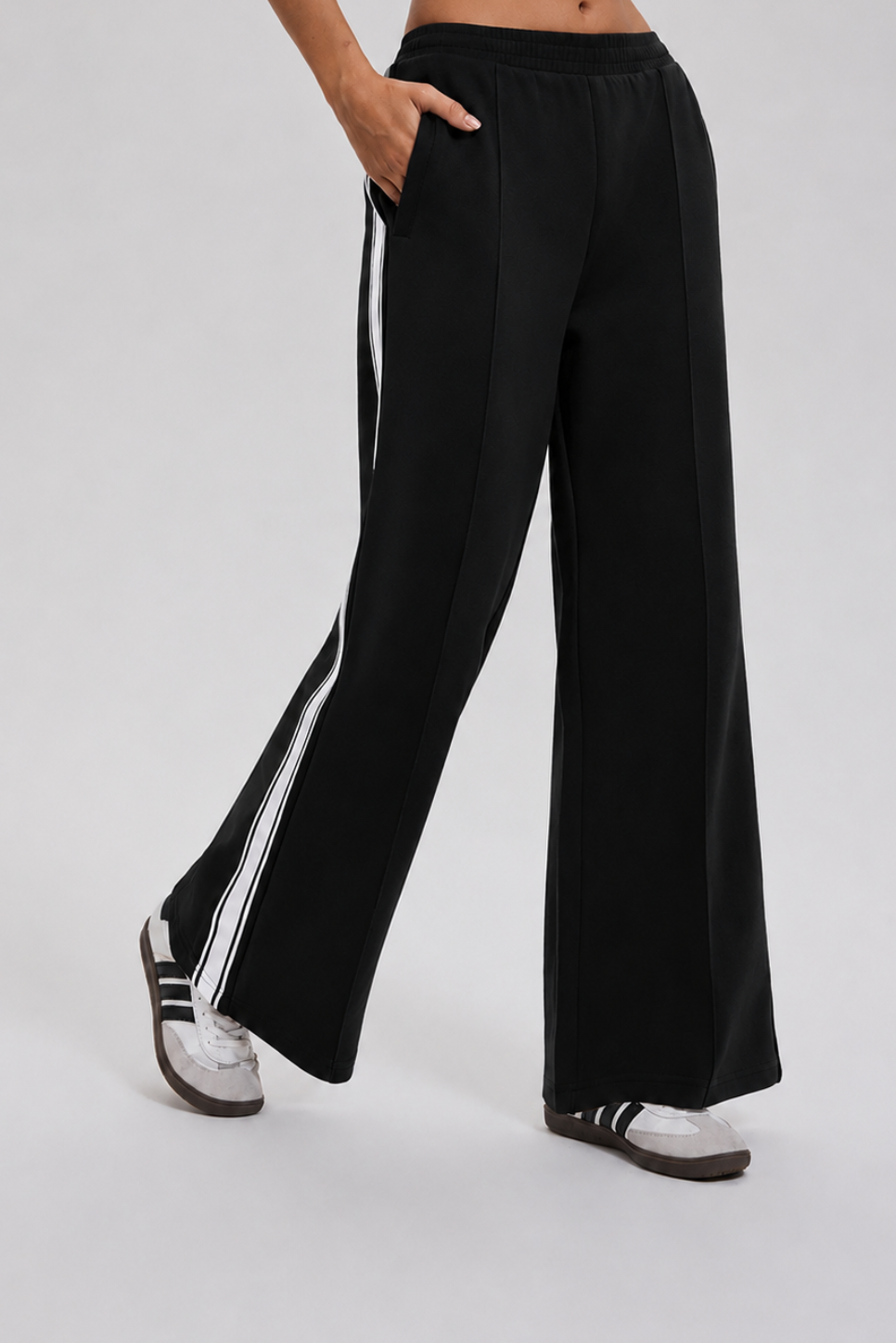 Black wide-leg pants with white stripes on a gray background