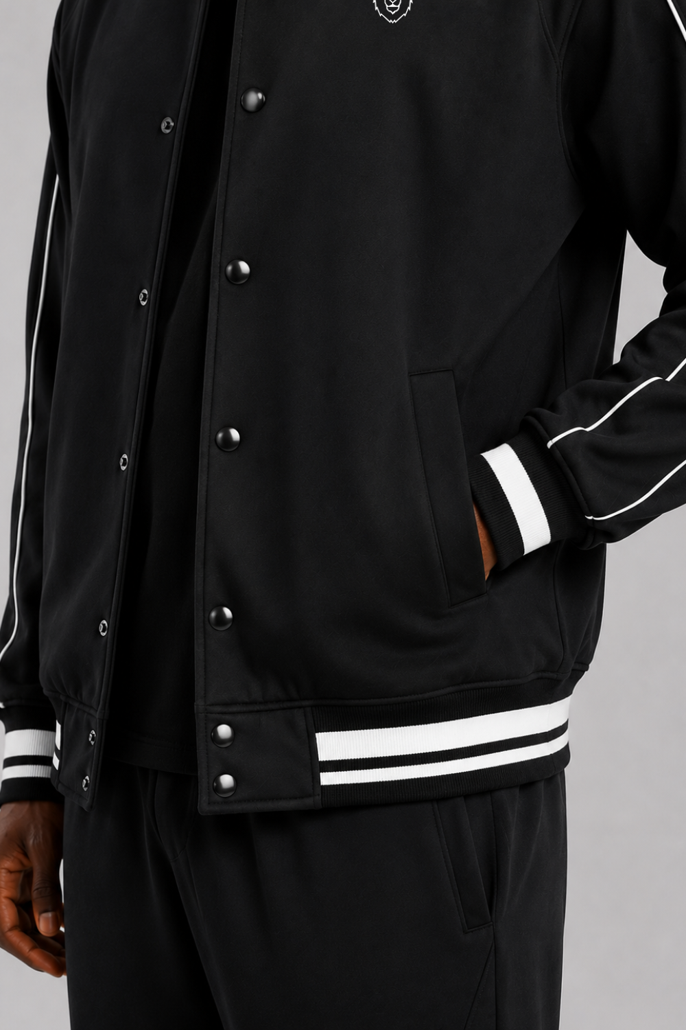 Black varsity jacket with white stripes on a gray background