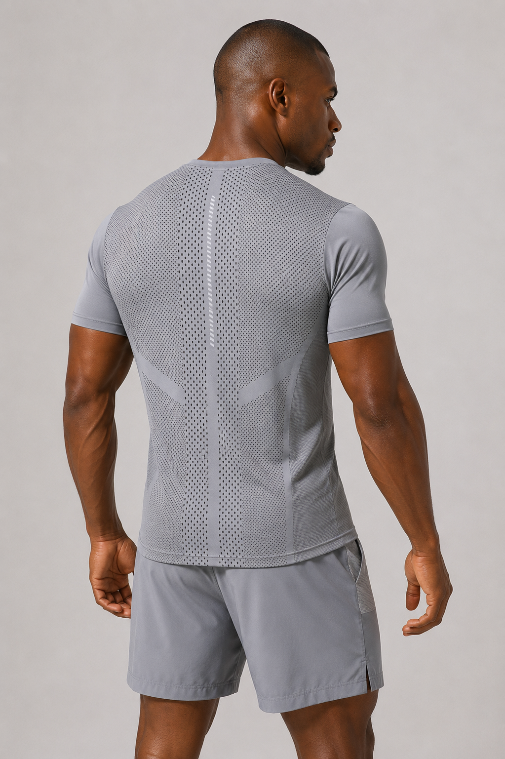 Man wearing a gray athletic outfit on a plain background