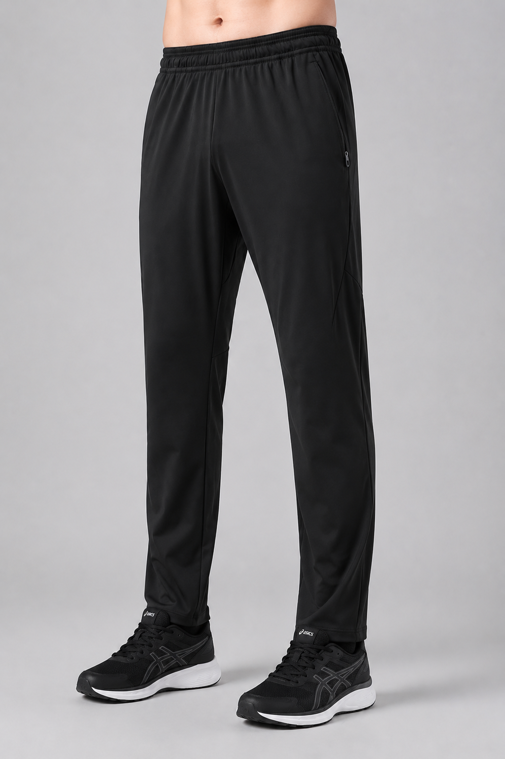 Black athletic pants worn by a person on a gray background