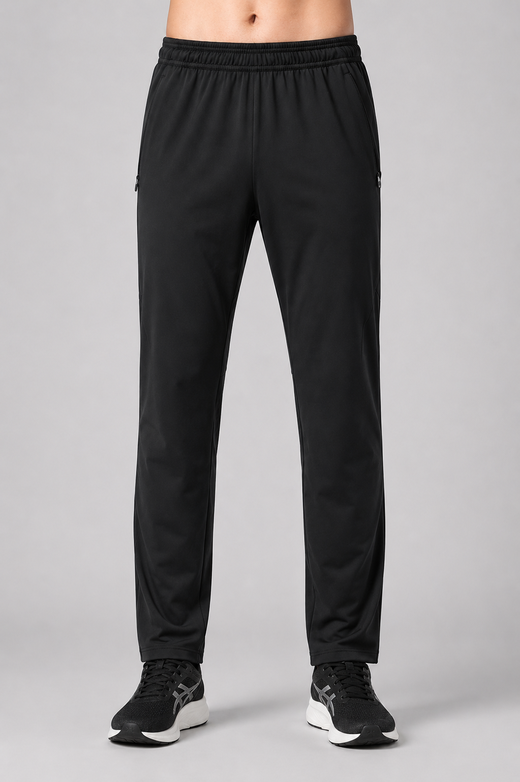 Black athletic pants worn by a person on a gray background