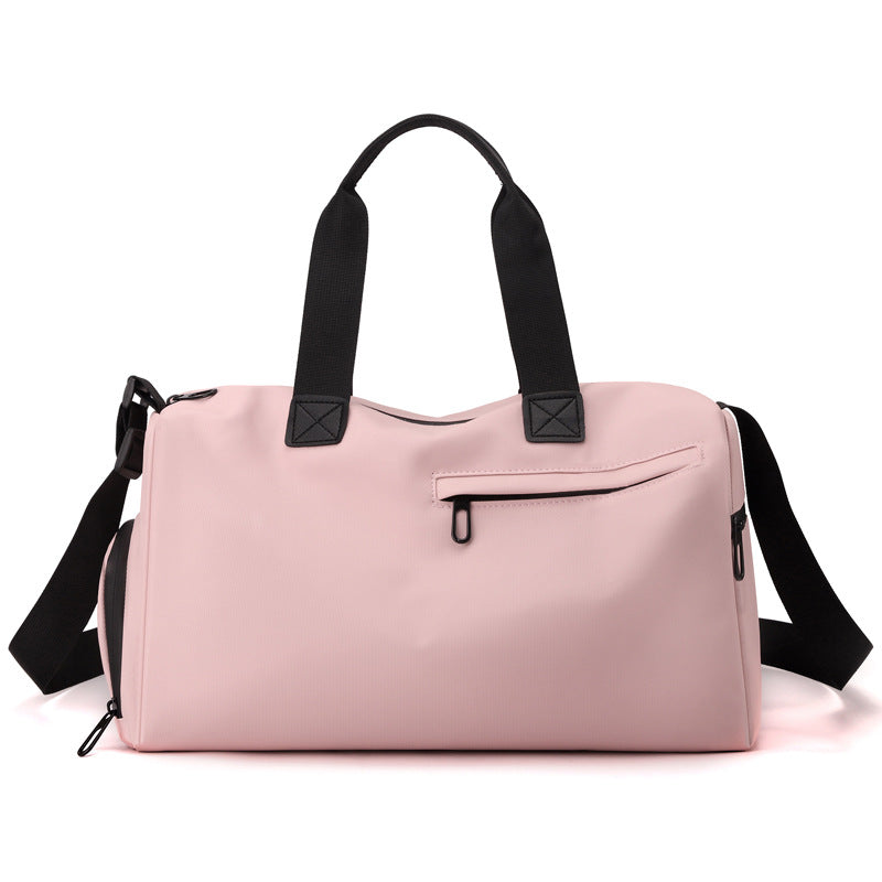 Pink duffel bag with black straps on a white background