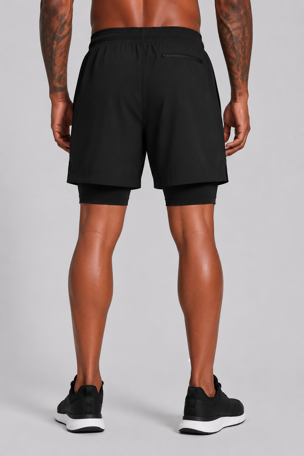 Person wearing black athletic shorts on a gray background