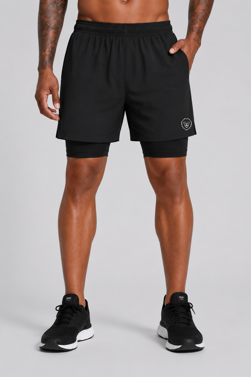 Person wearing black athletic shorts with a logo on a gray background
