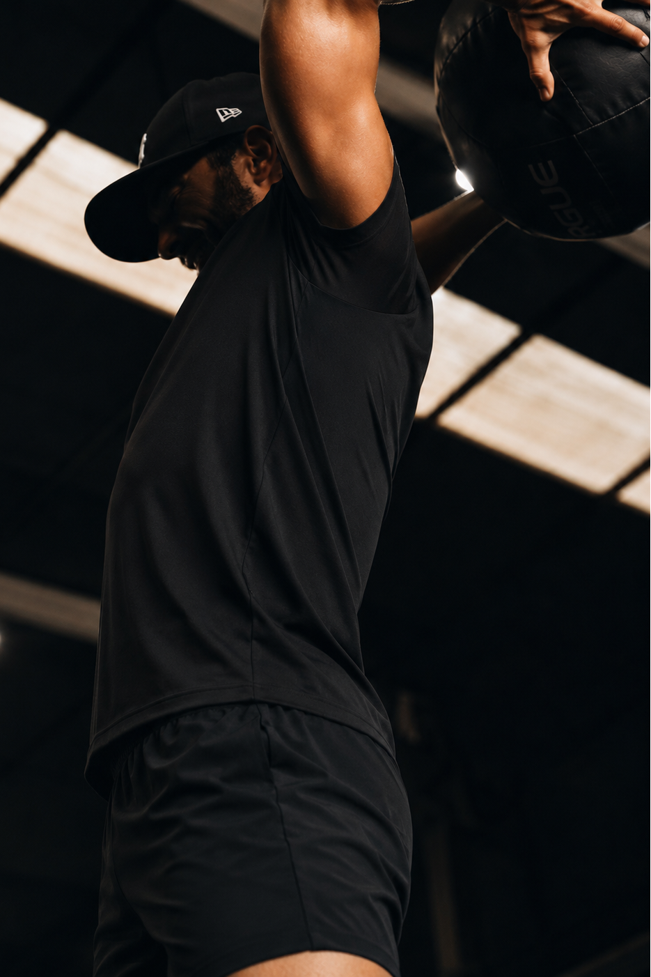 Person lifting a medicine ball in a gym setting