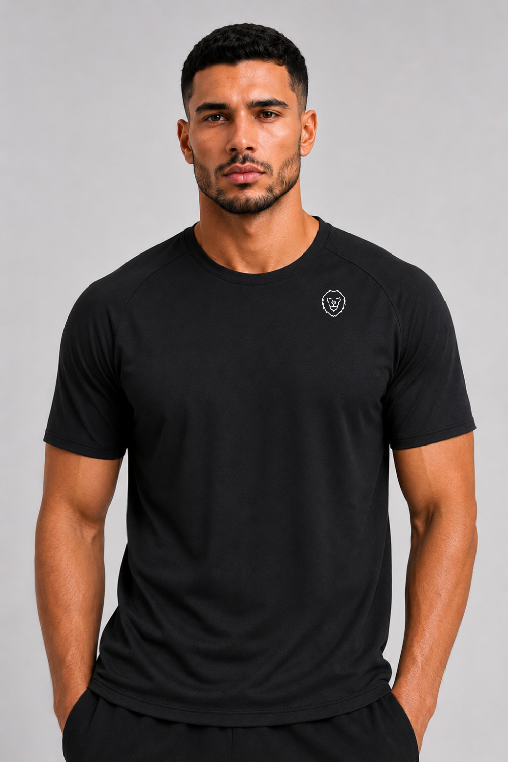 Man wearing a black t-shirt with a small logo on a gray background