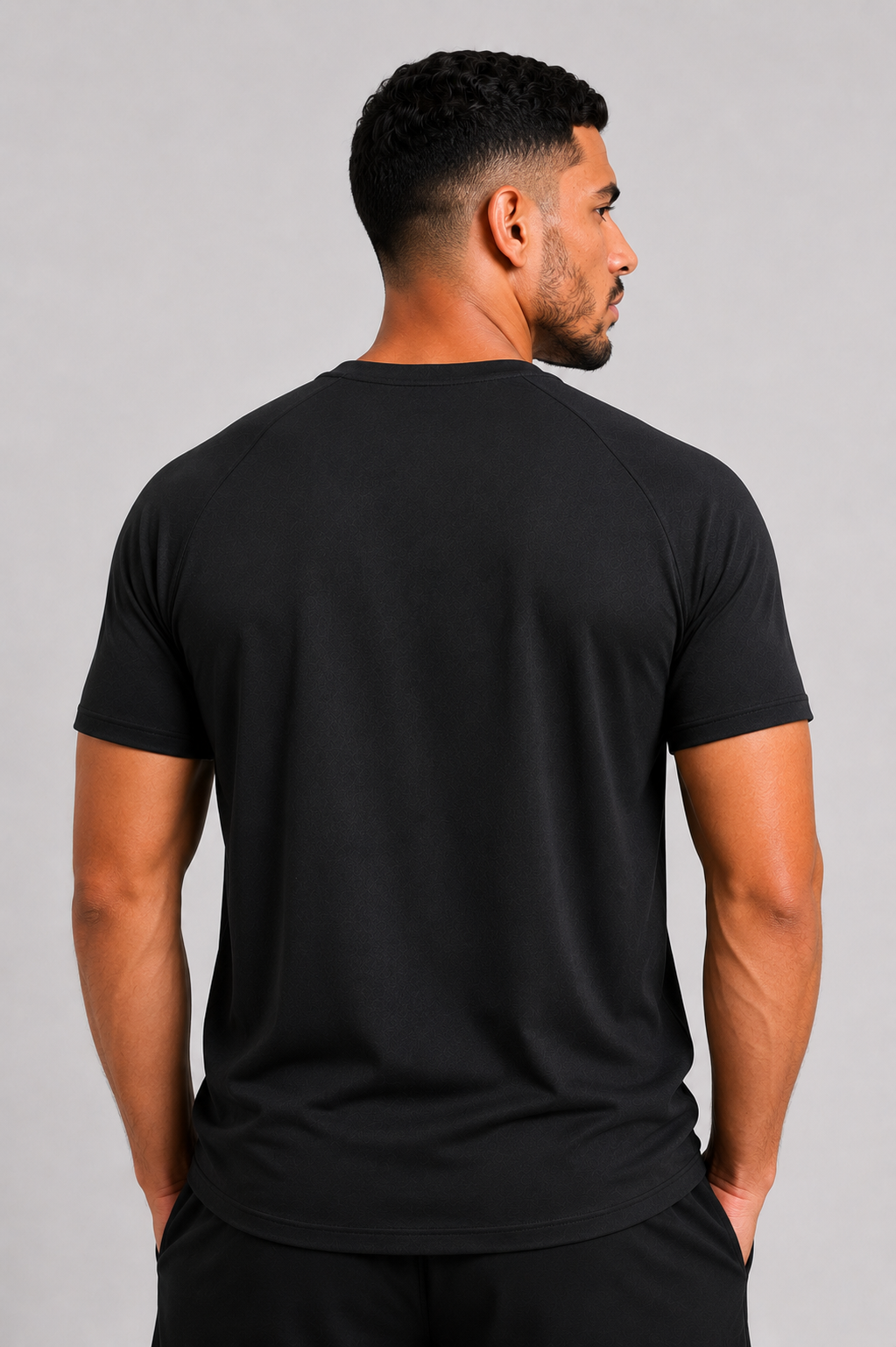 Man wearing a black t-shirt against a gray background